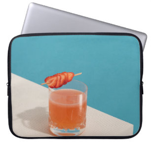 Clear drinking glass with brown liquid laptop sleeve