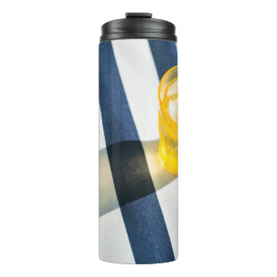 Clear drinking glass with yellow liquid thermal tumbler