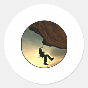 Climbing mountain man at sunset classic round sticker
