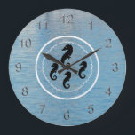 Clock - Seahorses, Water and White Rings<br><div class="desc">White porthole suggested by wavy circle within a solid circle,  encircles four black seahorses in center,  one large at top and three smaller beneath. Numerals have a three dimensional look in silver. Background of blue harbor water.</div>