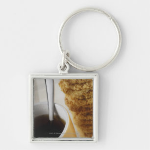 Close-up of a cup of coffee with cookies keychain