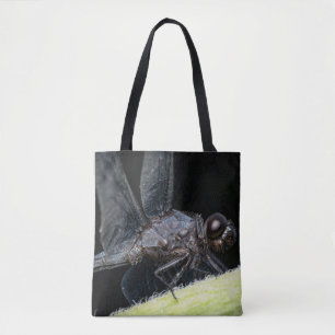 Close-up of a dragonfly, dark-eyed, perched on a l tote bag
