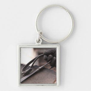 close-up of hand holding reins of horse keychain