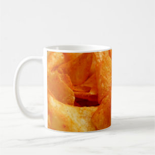 Close up of juicy, crispy, chips on black plate. coffee mug