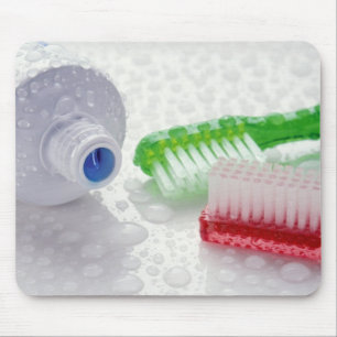 Close-up of toothpaste and toothbrushes covered mouse pad