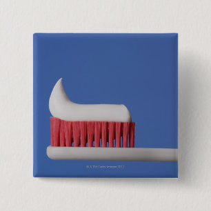 Close-up of toothpaste on a toothbrush 2 inch square button