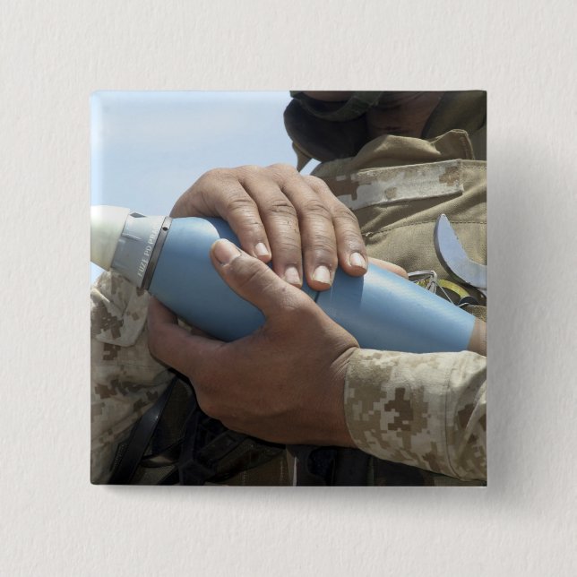 Close-up view of a soldier cradling a munition 2 inch square button (Front)