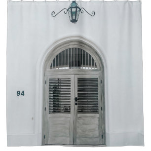 CLOSED GREY WOODEN DOOR BELOW BLACK LIGHT SCONCE