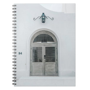 CLOSED GREY WOODEN DOOR BELOW BLACK LIGHT SCONCE NOTEBOOK