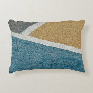 Closeup grey, yellow, and blue painted pavement accent pillow