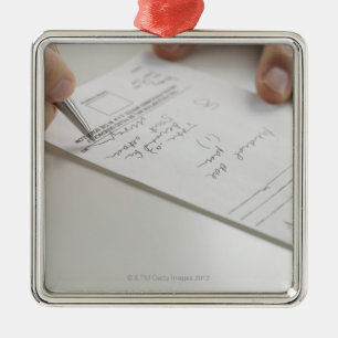 Closeup of hands signing prescription metal ornament