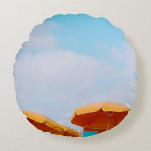 Closeup photo of lounger chairs and beach umbrella round pillow
