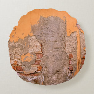 CLOSEUP PHOTO OF ORANGE AND GRAY WALL PAINT ROUND PILLOW