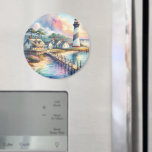 Coastal Lighthouse & Beach Cottages Scene Magnet<br><div class="desc">This serene coastal lighthouse painting captures the peaceful charm of seaside living with pastel skies, sun-drenched dunes, and gently rippling ocean waters. A classic striped lighthouse stands watch beside charming beach cottages, their warm windows glowing beneath a watercolor sky of soft pinks and blues. The wooden dock leads the eye...</div>