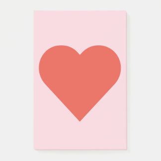 Coeur rouge sur la note de post-it rose d'arrière
