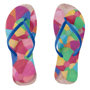 Colourful Beach Balls in Sand Flip Flops
