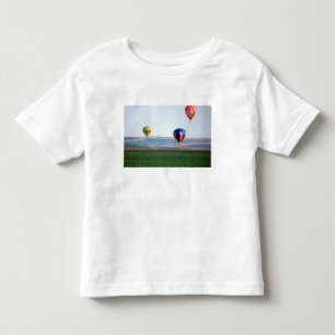 Colourful hot air balloons float over wheat toddler t-shirt