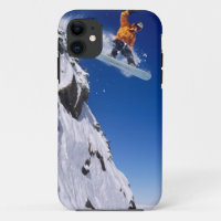 Un homme en snowboard sautant d'une corniche à