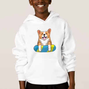 Corgi gallois à la nage avec planche