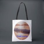 Couche de soleil beauté marine tote bag<br><div class="desc">Beauté Marine — Golden Sunset Wave & Shell A breathtaking golden hour photograph capturing a foamy wave gently washing over a small seashell on a sandy beach, bathed in warm sunset light. The reflections of gold and copper on the wet sand create a magical and poetic atmosphere, paired with the...</div>