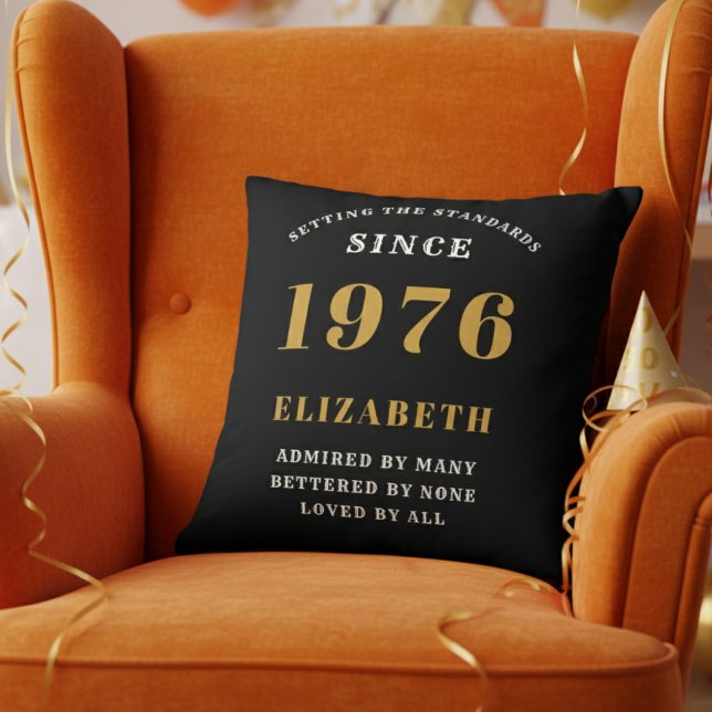 Coussin 50th Birthday Gift Personalized 1976 Black Gold (Personalized 50th birthday pillow on a vibrant orange velvet wingback chair)