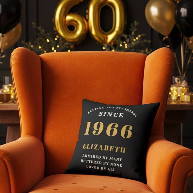Coussin 60th Birthday Gift Personalized 1966 Black Gold (A personalized black pillow on a vibrant orange velvet wingback armchair )