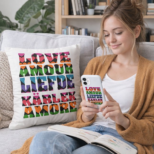 Coussin Amour en néons multilingues (A throw pillow that says love in multiple languages with a heart pattern.)