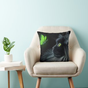 Coussin Chat noir fixant un papillon vert lumineux