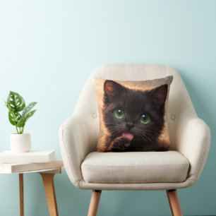 Coussin Chaton noir aux yeux verts se léchant la patte