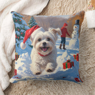 Coussin Chien maltais courant dans la neige avec un chapea