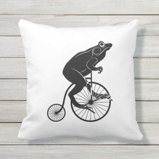 Coussin D'extérieur Grenouille ou crapaud noire et blanche sur un vélo