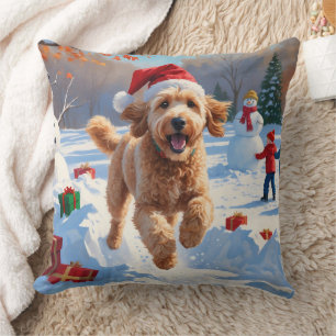 Coussin Goldendoodle courant dans la neige avec un chapeau