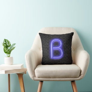 Coussin Initiale B dans l'éclairage néon sur brique