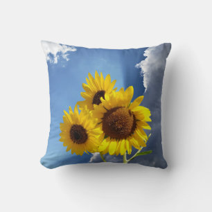 Coussin Trio de tournesols contre un ciel bleu avec des nu