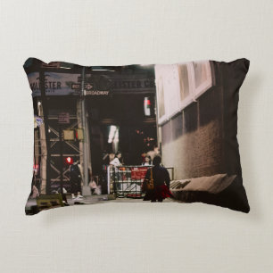 COUSSINS DÉCORATIFS FEMME EN ROBE NOIRE ET ROUGE MARCHANT LE LONG DE B