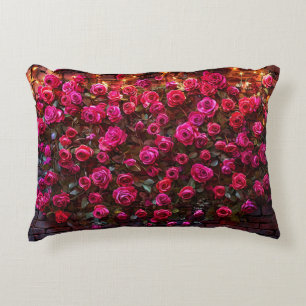 Coussins Décoratifs Roses roses sur un mur de briques avec des lumière