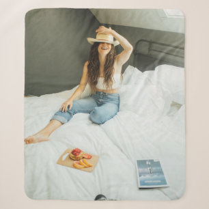 Couverture Sherpa Femme assise sur son lit tenant son casquette