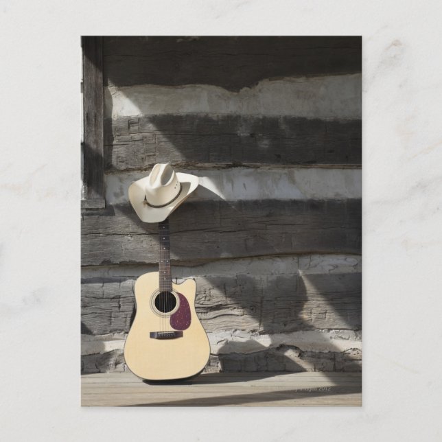 Cowboy hat on guitar leaning on log cabin postcard (Front)