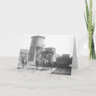 Cowboys on posing in front of a train card