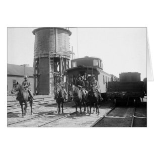 Cowboys sur des chevaux posant devant un train