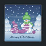 Crafty Snowman Knitting Scarf Magnet<br><div class="desc">Vector illustration of two adorable cartoon snowmen dressed in knitted hats and scarves. The big crafty snowman is knitting an oversized scarf for the little one. The scarf is already wrapped several times around the cute little snowman.</div>