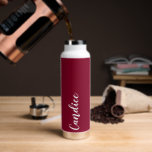Cranberry Red Personalized Wedding Bridesmaid Water Bottle<br><div class="desc">Gift your wedding bridesmaid or maid of honour with this trendy, vacuum Insulated water bottle that features her name in white, stylized script on a cranberry red colour background designed to match your wedding colour scheme. Personalize bottle by editing and replacing name with your own as desired. Select your water...</div>