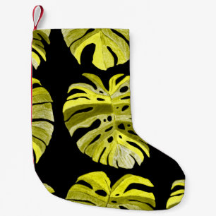 Creative seamless pattern with tropical leaves and small christmas stocking