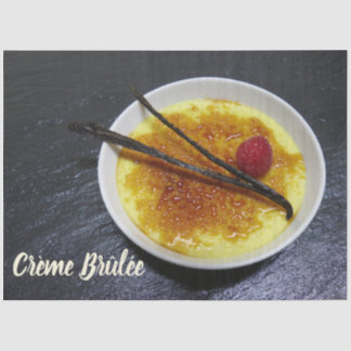 Creme brulee on slate with raspberry and vanilla tissue paper