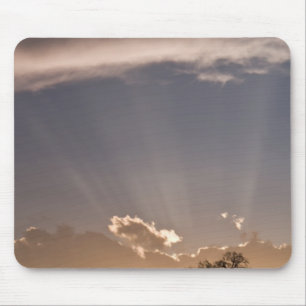 Crepuscular rays radiate across the sky at mouse pad