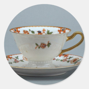 Cup and saucer with colourful flowers on it. classic round sticker