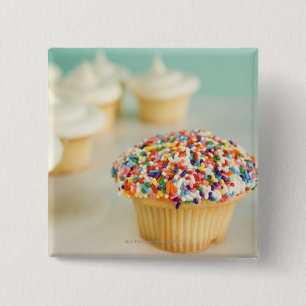 Cupcakes, focus on one in front with 2 inch square button