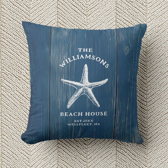 Custom Blue Coastal Starfish Beach House Throw Pillow (A blue pillow with a white starfish and text reading "The Williamsons Beach House" rests on beige)