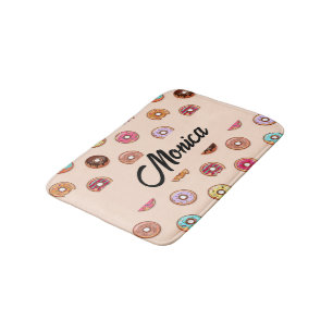 Cute decorative doughnuts on pink bath mat