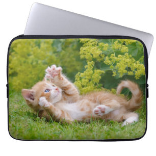 Cute funny cat kitten playing in a flowery garden  laptop sleeve